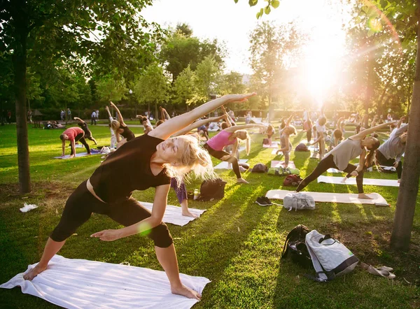 Big group of adults attending a yoga class outside in park — Stock Photo, Image