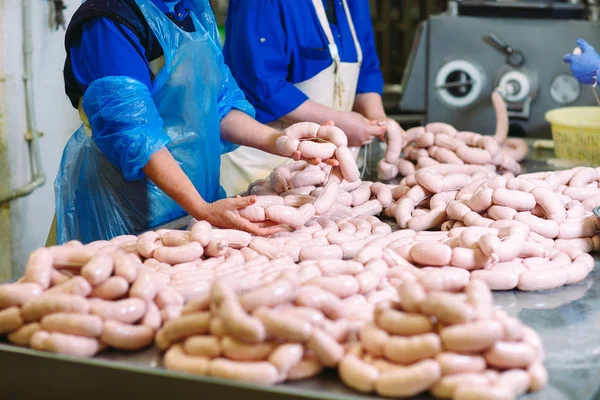 Bouchers transformant des saucisses dans une usine de viande . — Photo
