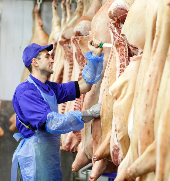 Carnicero cortando carne de cerdo en la fabricación de carne . — Foto de Stock