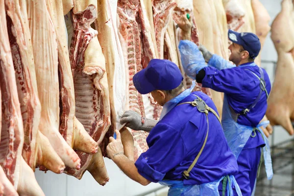 Carnicero cortando carne de cerdo en la fabricación de carne . — Foto de Stock