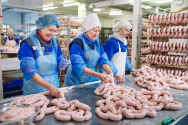 Kasaplar et fabrikasında sosis işliyor.