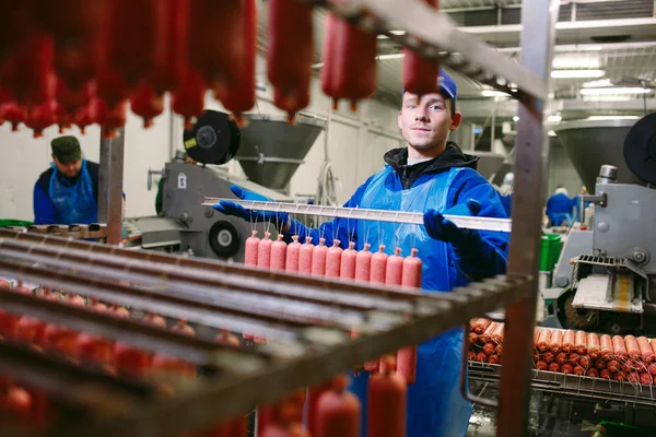 Portret rzeźników przetwarzających kiełbaski w fabryce mięsnej — Zdjęcie stockowe
