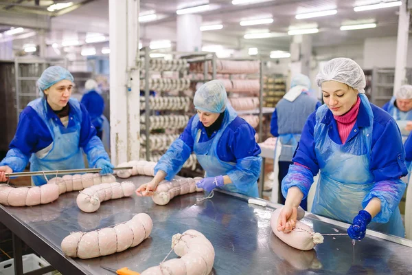 Metzger verarbeitet Wurst in der Fleischfabrik. — Stockfoto