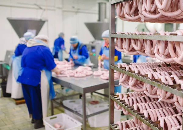 Butchers processing sausages at the meat factory. — Stock Photo, Image