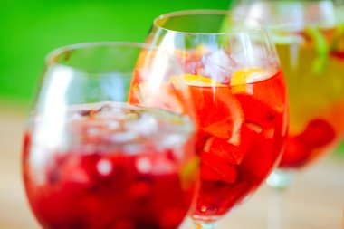 Yaz kokteyli. Yeşil arka planda meyve kokteyli. Narenciye, çilek, çilek, yaban mersini, nane, buz