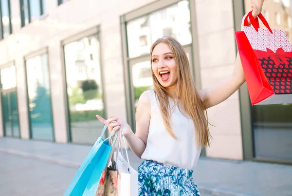 Životní styl portrét mladá blonďatá dívka s nákupníma taškama z obchodu — Stock fotografie