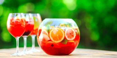 Yaz kokteyli. Yeşil arka planda meyve kokteyli. Narenciye, çilek, çilek, yaban mersini, nane, buz