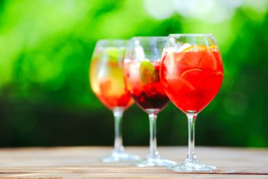 Yaz kokteyli. Yeşil arka planda meyve kokteyli. Narenciye, çilek, çilek, yaban mersini, nane, buz