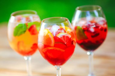 Yaz kokteyli. Yeşil arka planda meyve kokteyli. Narenciye, çilek, çilek, yaban mersini, nane, buz