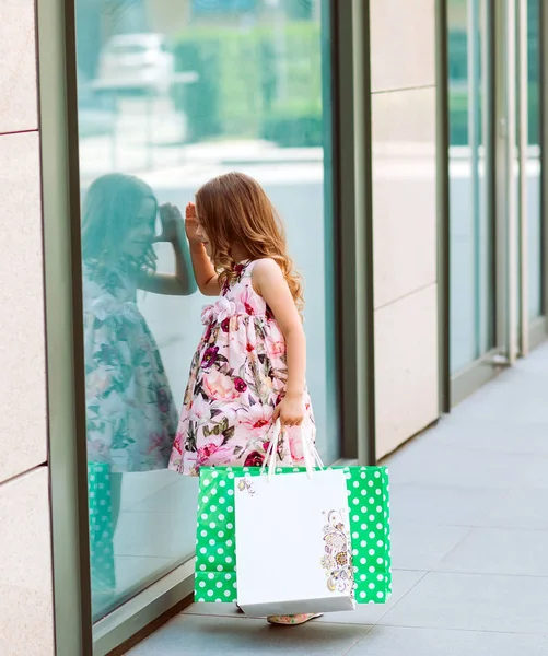 Pencere Alışveriş Merkezi yakınındaki küçük kız bakar — Stok fotoğraf