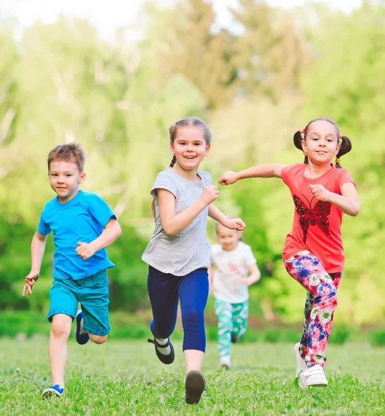 Багато різних дітей, хлопчиків і дівчаток біжать в парку в сонячний літній день в повсякденному одязі . — стокове фото