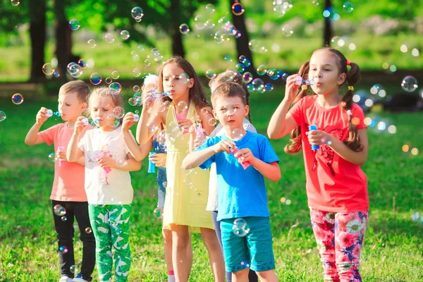 Die Gruppe von Kindern, die Seifenblasen pusten. — Stockfoto