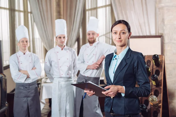 Restaurantleiter und seine Mitarbeiter in der Küche. Interaktion mit Küchenchef in der Großküche. — Stockfoto