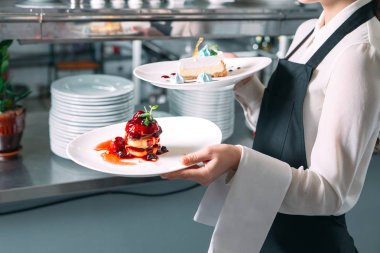 Garson lokantada görev başında. Garson bulaşıkları taşıyor..