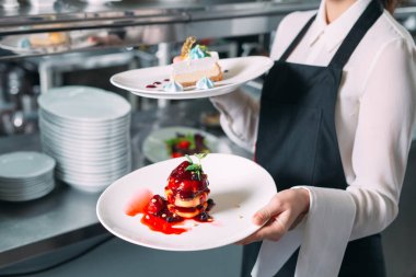 Garson lokantada görev başında. Garson bulaşıkları taşıyor..