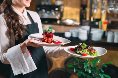 Garson lokantada görev başında. Garson bulaşıkları taşıyor..