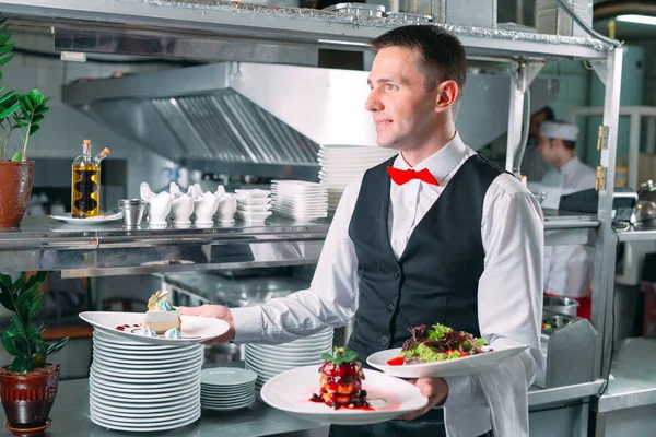 Cameriere che serve in movimento al ristorante. Il cameriere porta i piatti. — Foto Stock