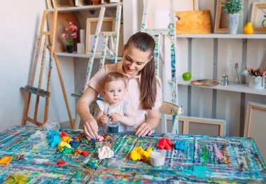Kinetik kumla oynayan anne ve kızı.