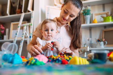 Kinetik kumla oynayan anne ve kızı.