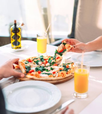 Bir çift bir restoranda pizza yiyor.