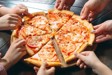 Ahşap masada Pizza dilimleri alarak eller, yakın görünüm.