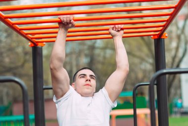 Maymun barları üzerinde fit adam çapraz eğitim . Dışında bir açık spor salonunda brachiation merdivenfitness egzersiz