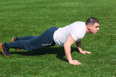 Fitness adam tahta egzersiz eğitimi Park açık havada. Genç adam yapar egzersiz. Sağlıklı yaşam, jimnastik kavramı.