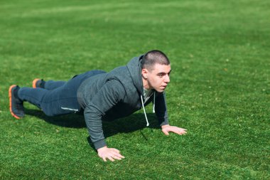 Fitness adam tahta egzersiz eğitimi Park açık havada. Genç adam yapar egzersiz. Sağlıklı yaşam, jimnastik kavramı.