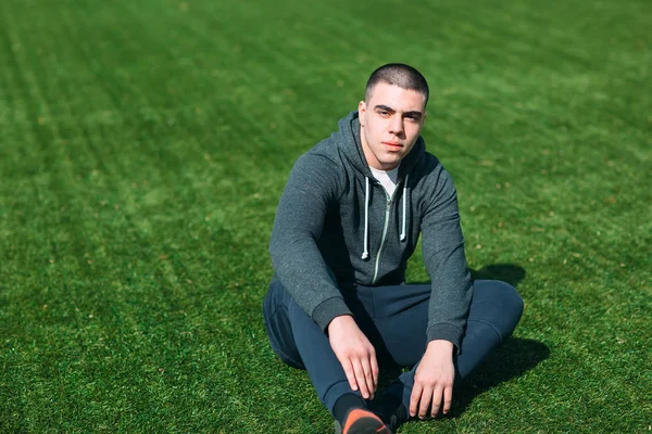 Sportlicher Mann trainiert auf dem Rasen — Stockfoto