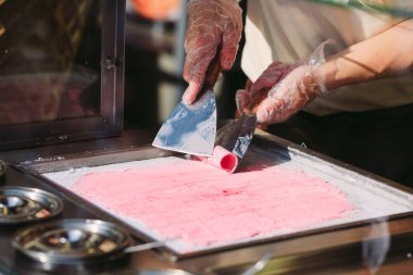 dondurma tavada tavada tavada kızartılmış dondurma ruloları. Organik, doğal haddelenmiş dondurma, el yapımı tatlı