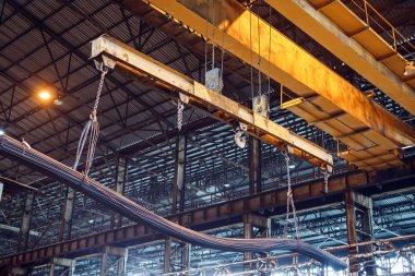 Turna yükleyici fabrikada demir çubuk ve tel çubuk taşıyor.