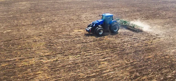 Bir traktör tarlayı sürüyor ve ekiyor..
