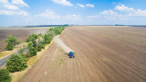 Ein Traktor pflügt und sät auf dem Feld. — Stockfoto