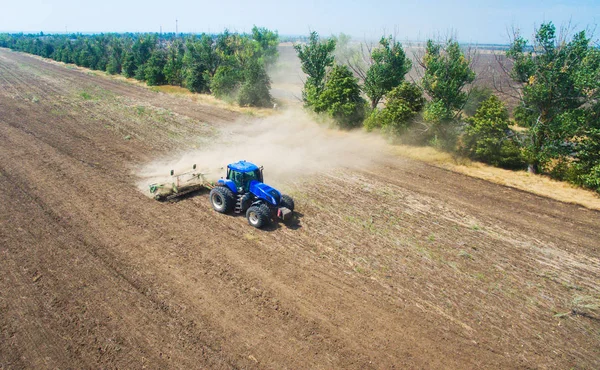 Ein Traktor pflügt und sät auf dem Feld. — Stockfoto