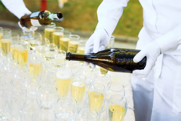 Barman in witte handschoenen gieten Champagne in glazen. — Stockfoto
