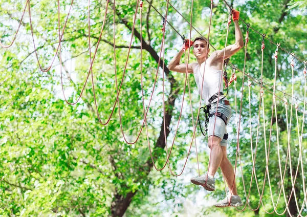 Člověk tráví svůj volný čas na laně. Muž v provazovém parku — Stock fotografie