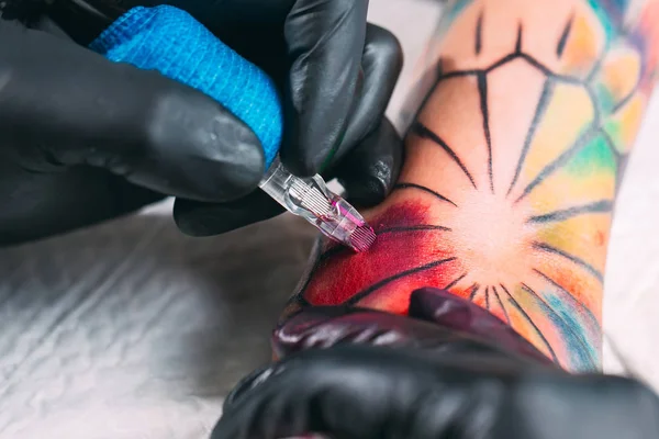 Профессиональный татуировщик делает татуировку на руке молодой девушки. — стоковое фото