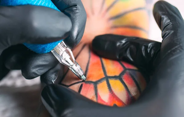 Profesionální tetování umělec dělá tetování na mladé dívky ruku. — Stock fotografie