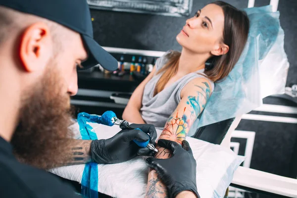 Tatuaggio artista professionista fa un tatuaggio su una mano di giovani ragazze. — Foto Stock