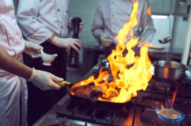 Mutfakta yangın var. Ateş yanığı demir tavada pişiyor, ateş çok sıcak..