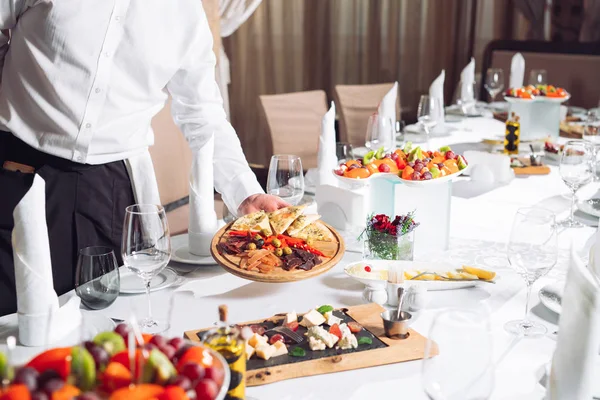 Mesero sirviendo mesa en el restaurante preparándose para recibir invitados. — Foto de Stock