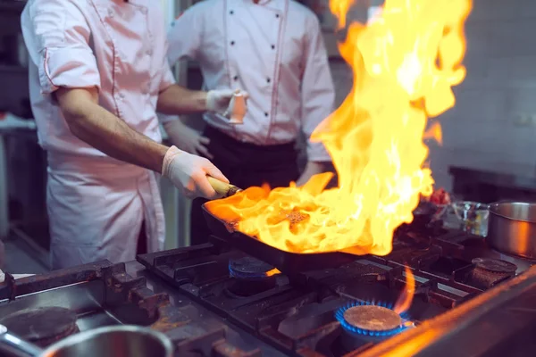 Ogień w kuchni. Ogniste spalanie gazu gotuje się na żelaznej patelni, rozpalić ogień bardzo gorąco. — Zdjęcie stockowe