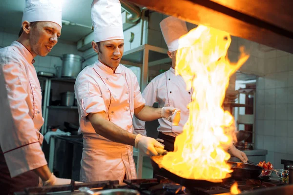 Eld i köket. Brandgasförbränning är matlagning på järnpanna, rör eld mycket varmt. — Stockfoto