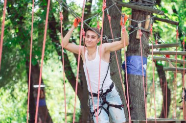 Adam boş zamanlarını ip kursunda geçiriyor. İp parkındaki adam..