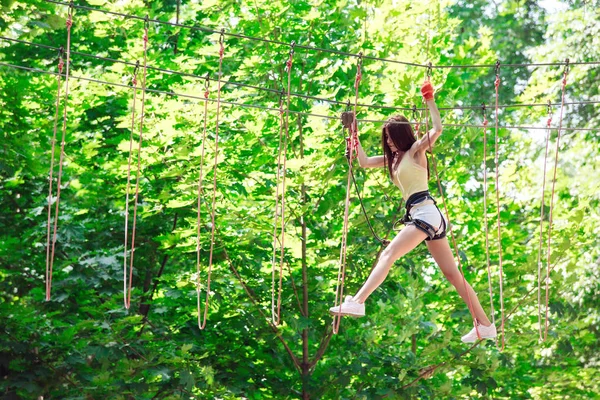 Couple spend their leisure time in a ropes course. man and woman engaged in rock-climbing, — Stock Photo, Image