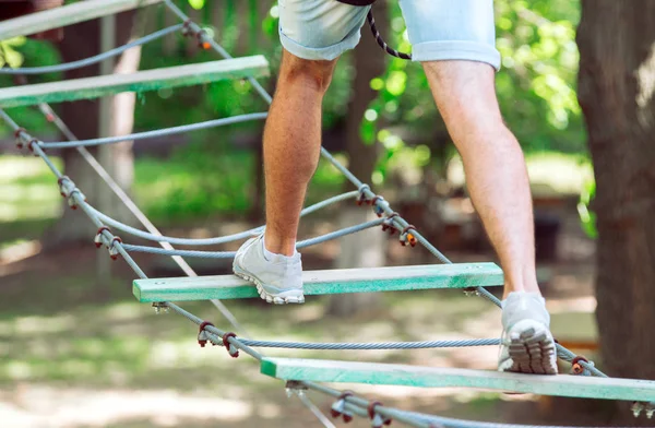 El hombre pasa su tiempo libre en un curso de cuerdas. Hombre ocupado en el parque de cuerdas — Foto de Stock