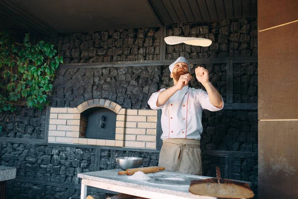 Yetenekli aşçı pizza için hamur hazırlıyor, elleriyle yuvarlanıyor ve kusuyor.. — Stok fotoğraf