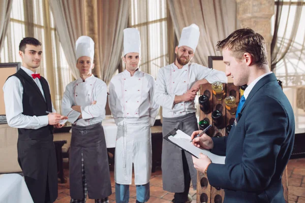 Direttore del ristorante e il suo staff in cucina. interagire con il capo chef in cucina commerciale — Foto Stock