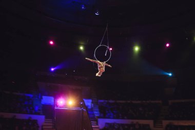 Hava acrobat içinde belgili tanımlık çalmak. Genç bir kız akrobatik öğeleri hava ringde gerçekleştirir.