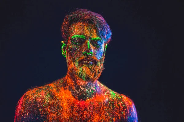 Concepto. Retrato de un hombre barbudo. El hombre está pintado en polvo ultravioleta —  Fotos de Stock